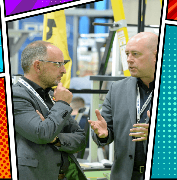 Two men talking at a busy IMHX expo