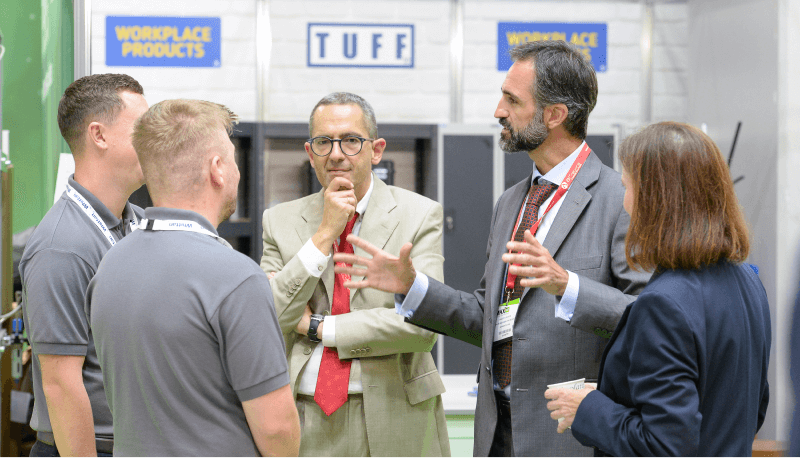 Professionals in business attire engaged in a discussion at a conference